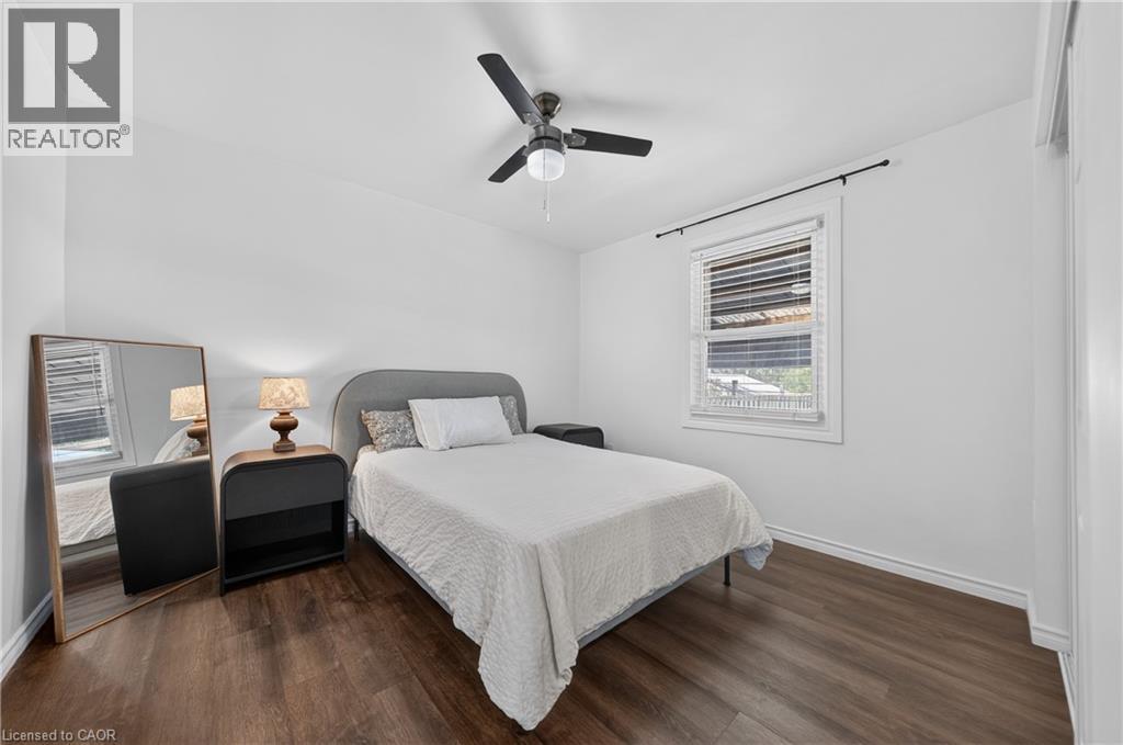 Room with dark wood-finish flooring, white walls, and a window with white blinds - 621 Tate Avenue, Hamilton, ON - Indoor Photo Showing Bedroom