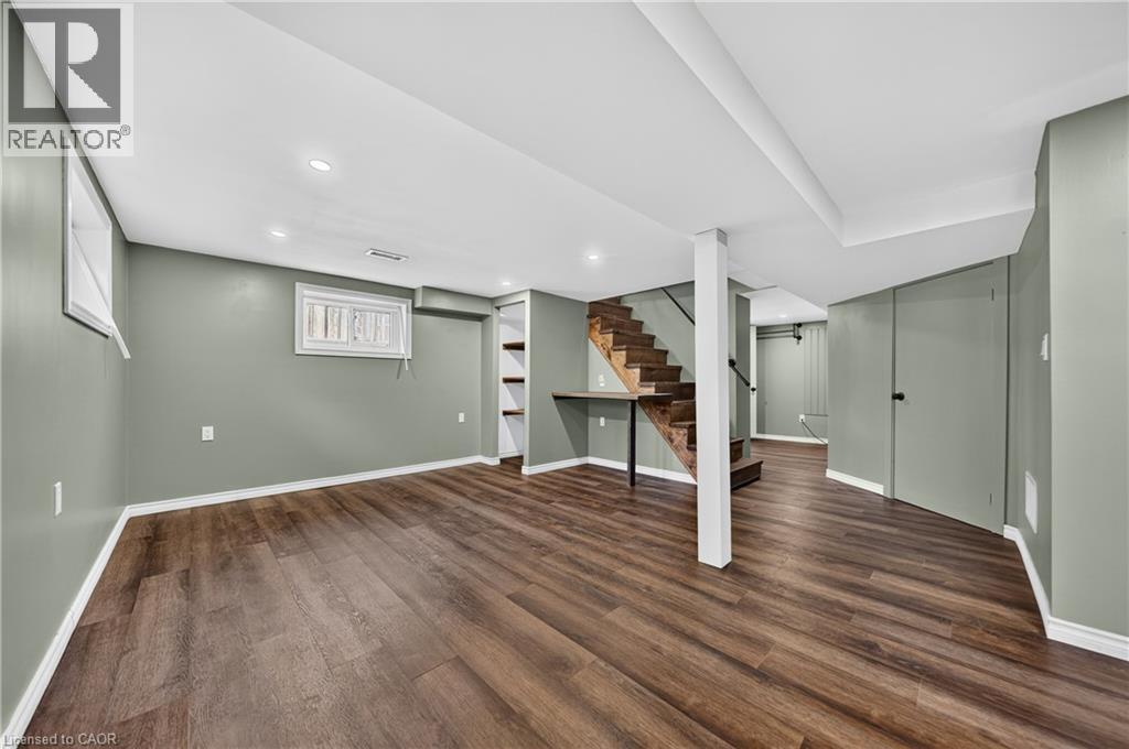 Spacious room featuring wood-finish flooring, recessed lighting, and light green walls - 621 Tate Avenue, Hamilton, ON - Indoor