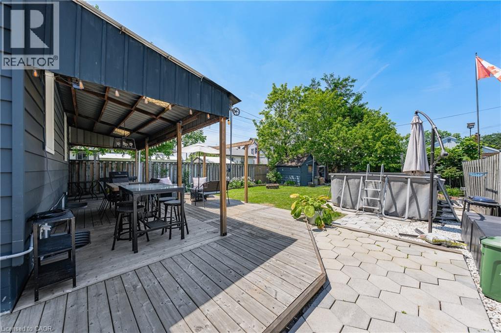 Spacious outdoor area featuring a covered deck, wood decking, and a paver stone patio - 621 Tate Avenue, Hamilton, ON - Outdoor With Deck Patio Veranda With Exterior