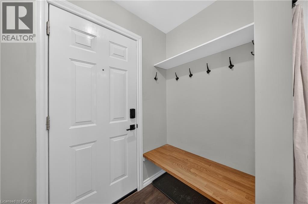 Entryway featuring a white paneled door with smart lock, built-in wooden bench, integrated shelf, and wall-mounted coat hooks - 621 Tate Avenue, Hamilton, ON - Indoor Photo Showing Other Room