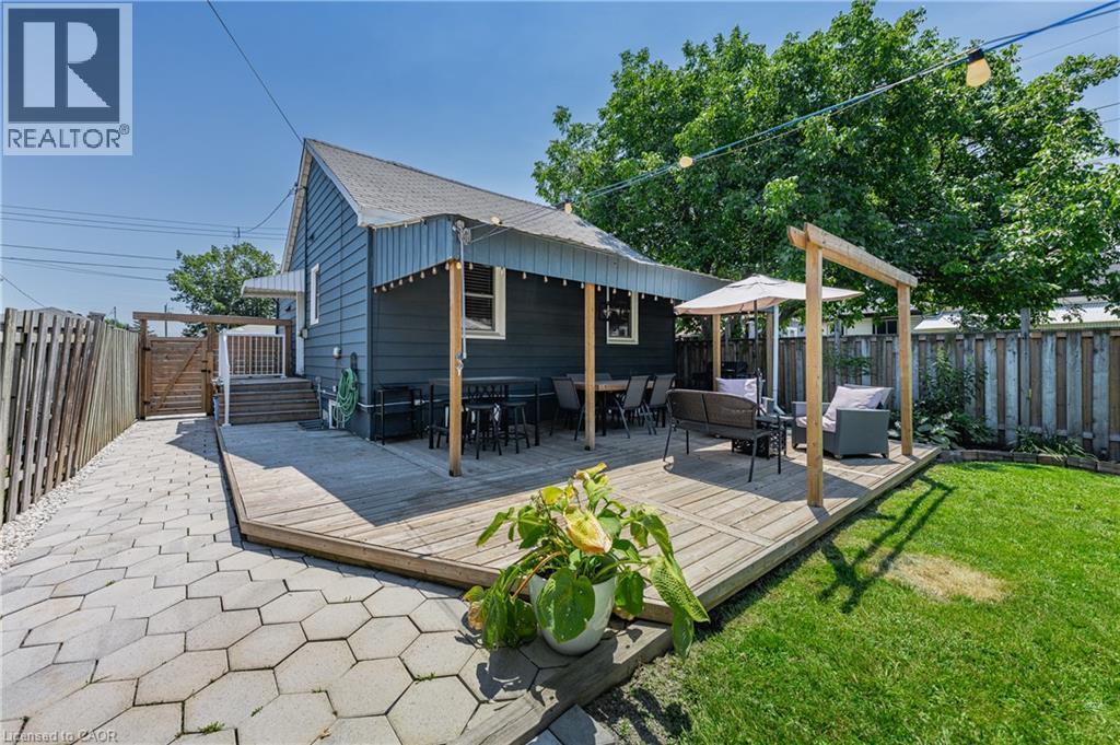 Expansive backyard featuring a wood deck, paver patio, and grassy area - 621 Tate Avenue, Hamilton, ON - Outdoor With Deck Patio Veranda