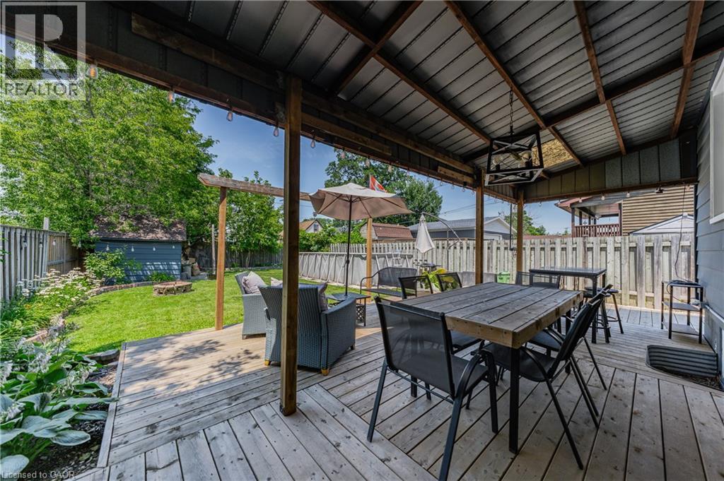 Expansive covered wood-finish deck with a corrugated metal roof and exposed wood beams - 621 Tate Avenue, Hamilton, ON - Outdoor With Deck Patio Veranda With Exterior