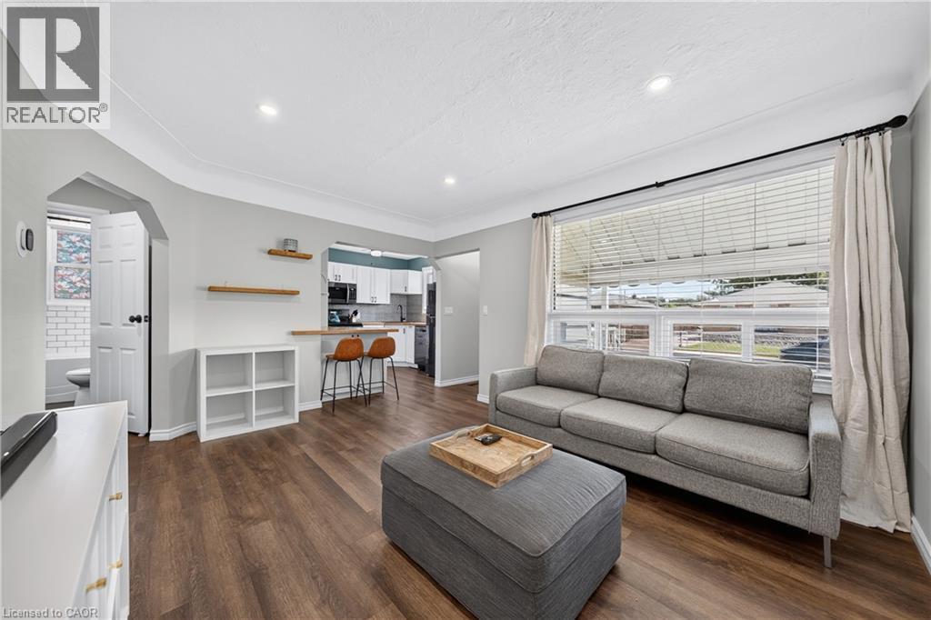 Open-concept living space featuring wood-finish flooring, recessed lighting, and a large window - 621 Tate Avenue, Hamilton, ON - Indoor Photo Showing Living Room