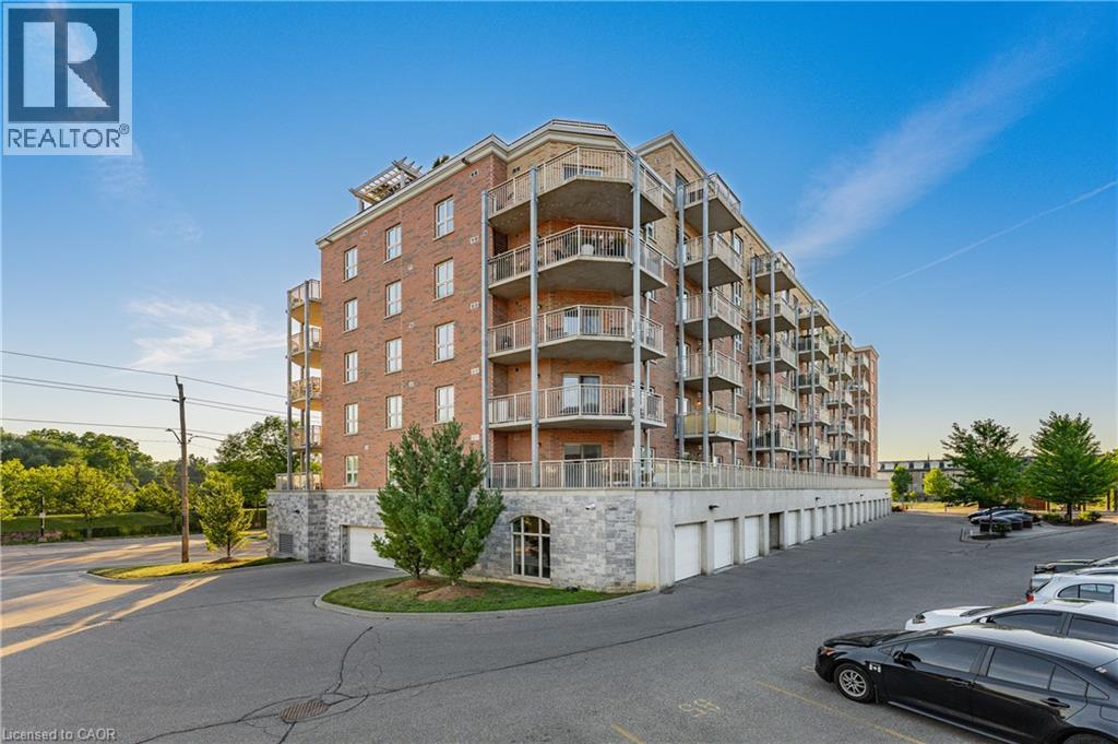 Multi-story residential building featuring a brick facade and stone-clad lower levels - 155 Water Street S Unit# 203, Cambridge, ON - Outdoor With Facade