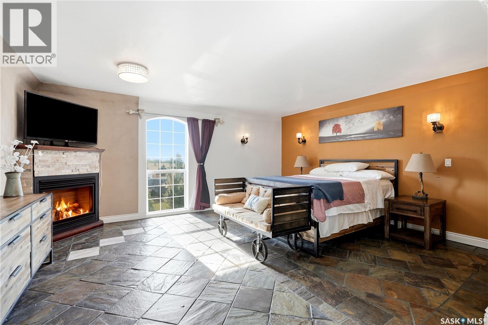 308 3Rd Street W, Delisle, SK - Indoor Photo Showing Bedroom With Fireplace
