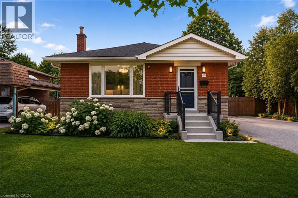 Brick and stone veneer exterior featuring a covered front entry with steps and wrought iron railings - 715 Drury Lane, Burlington, ON - Outdoor