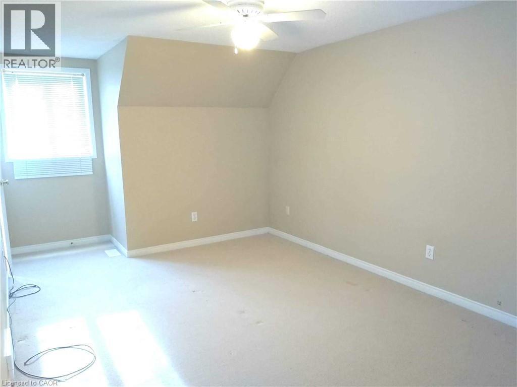 Carpeted room featuring a ceiling fan, a window with blinds, and neutral wall paint - 426 Downsview Place, Waterloo, ON - Indoor Photo Showing Other Room