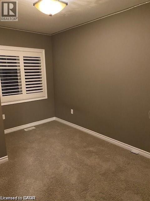 Carpeted room with neutral wall tones and white baseboards - 4 Isaiah Drive, Kitchener, ON - Indoor Photo Showing Other Room