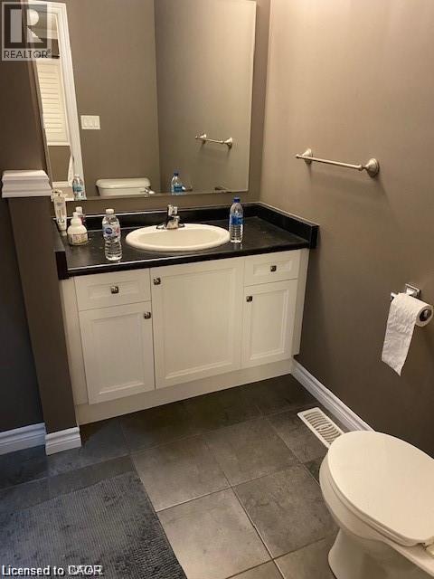 White vanity with a black countertop and an integrated sink - 4 Isaiah Drive, Kitchener, ON - Indoor Photo Showing Bathroom