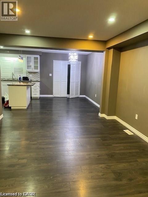 Open-concept living area featuring wood-finish flooring, recessed lighting, and a crystal chandelier - 4 Isaiah Drive, Kitchener, ON - Indoor Photo Showing Other Room