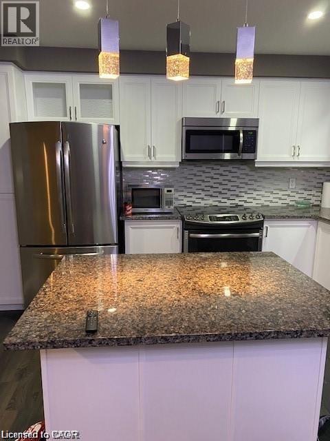 Kitchen island with a polished stone countertop and pendant lighting - 4 Isaiah Drive, Kitchener, ON - Indoor Photo Showing Kitchen With Stainless Steel Kitchen With Upgraded Kitchen