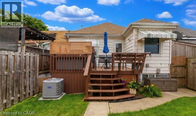 Rear exterior featuring a multi-level wood deck, privacy lattice, and a concrete patio - 237 Paling Avenue, Hamilton, ON - Outdoor With Deck Patio Veranda With Exterior