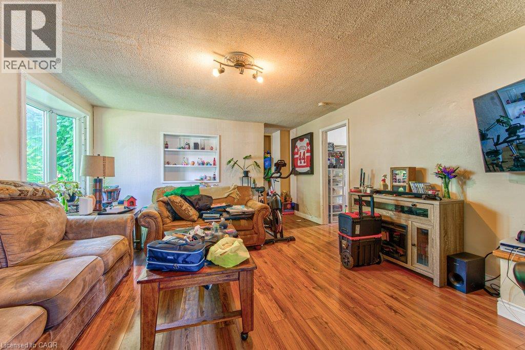 Spacious living area featuring wood-finish flooring, a bay window, and a built-in display shelf - 819 Duke Street, Cambridge, ON - Indoor Photo Showing Living Room