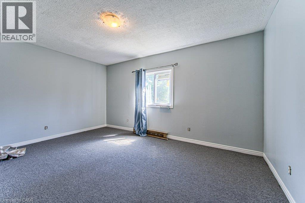 Spacious room featuring light gray walls, plush gray carpeting, and white baseboards - 819 Duke Street, Cambridge, ON - Indoor Photo Showing Other Room