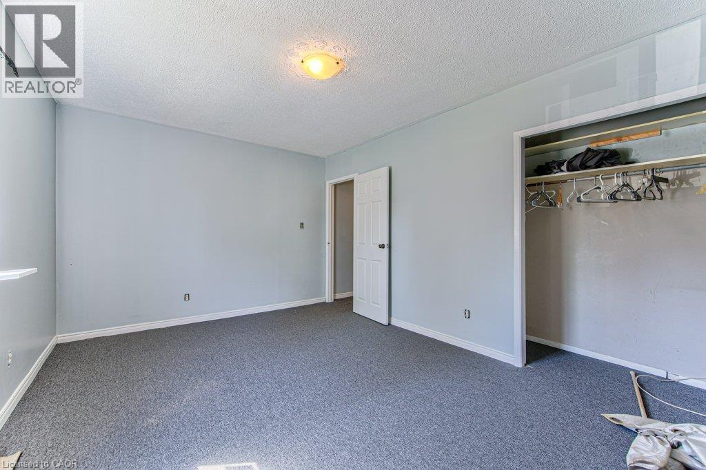 Interior room featuring light blue painted walls, gray carpet flooring, white baseboards, and a built-in closet with a hanging rod - 819 Duke Street, Cambridge, ON - Indoor Photo Showing Other Room