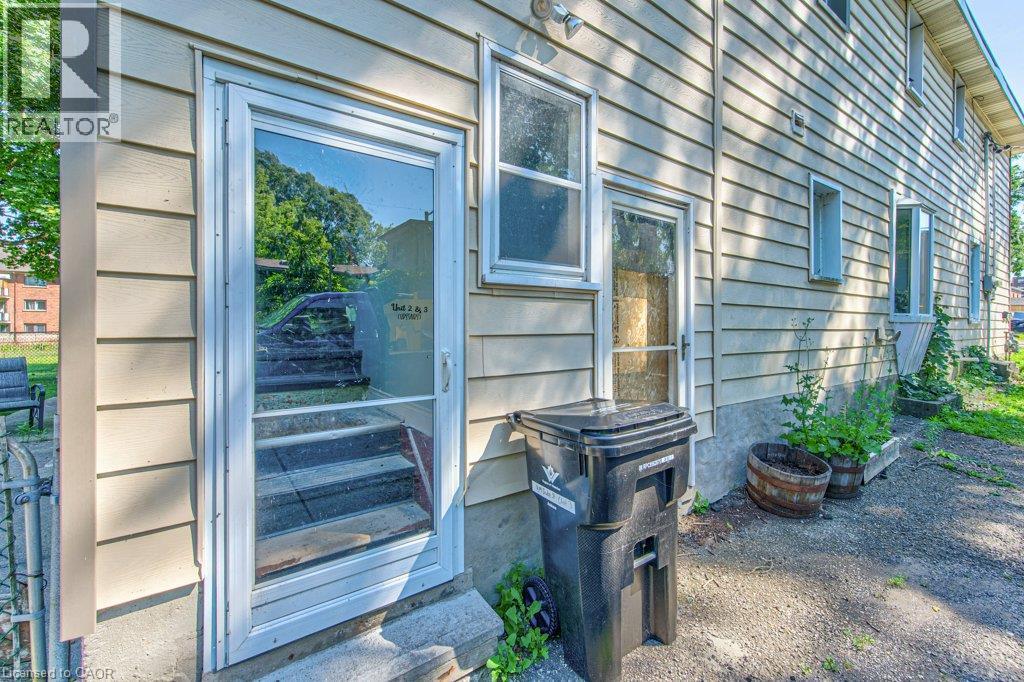 Side entrance featuring a storm door, concrete steps, and horizontal siding - 819 Duke Street, Cambridge, ON - Outdoor