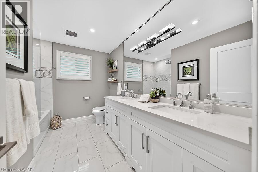 Dual vanity with integrated sinks and white countertops - 30 Carriagegate Drive, Hamilton, ON - Indoor Photo Showing Bathroom