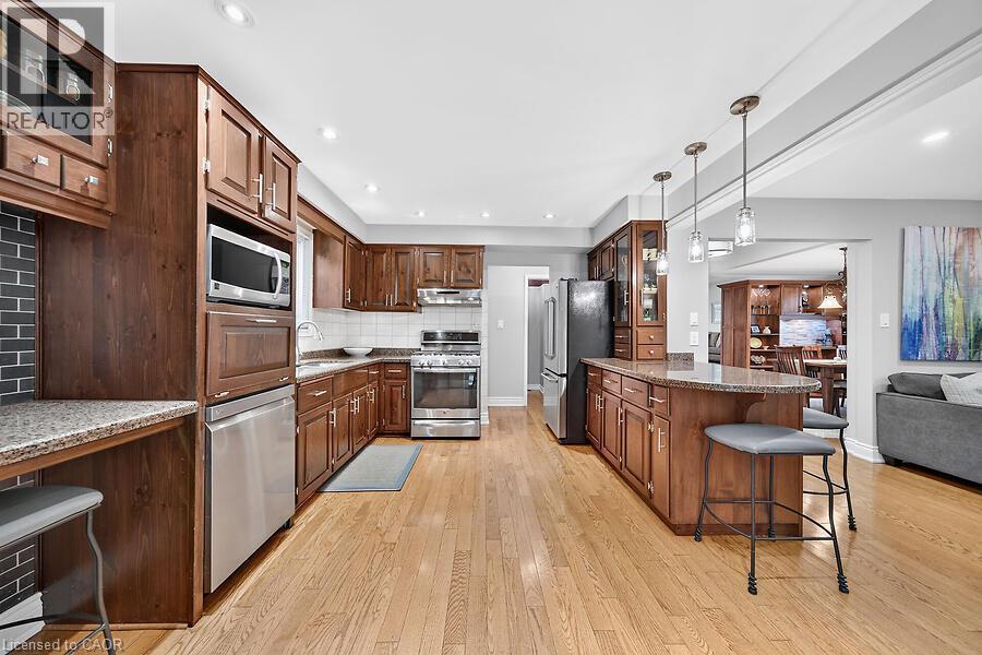 Spacious kitchen featuring wood-finish flooring, recessed lighting, and stainless steel appliances - 30 Carriagegate Drive, Hamilton, ON - Indoor Photo Showing Kitchen With Stainless Steel Kitchen