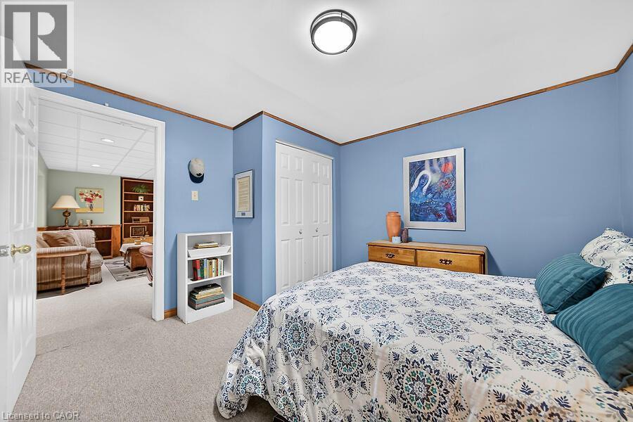 Carpeted room with blue walls, white bi-fold closet doors, and wood trim detailing - 30 Carriagegate Drive, Hamilton, ON - Indoor Photo Showing Bedroom