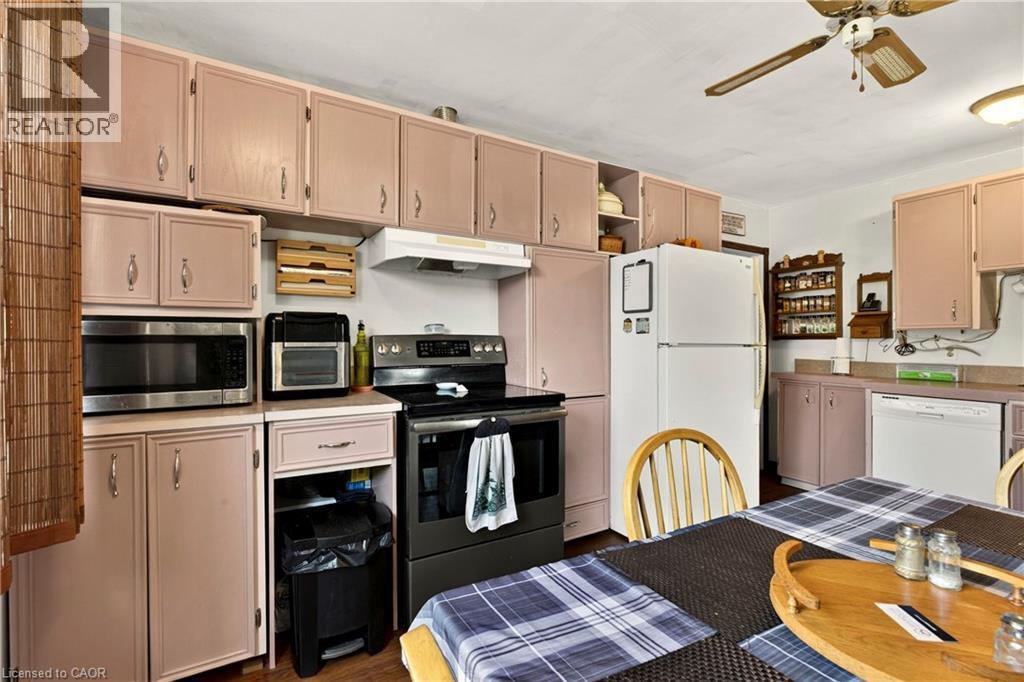 Kitchen featuring extensive cabinetry, white appliances, and a ceiling fan - 958 Highland Road E, Hamilton, ON