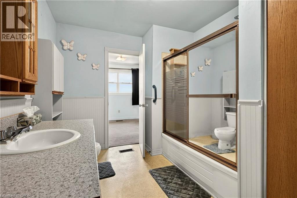 Bathroom with a single basin vanity featuring a speckled countertop and chrome faucet - 958 Highland Road E, Hamilton, ON