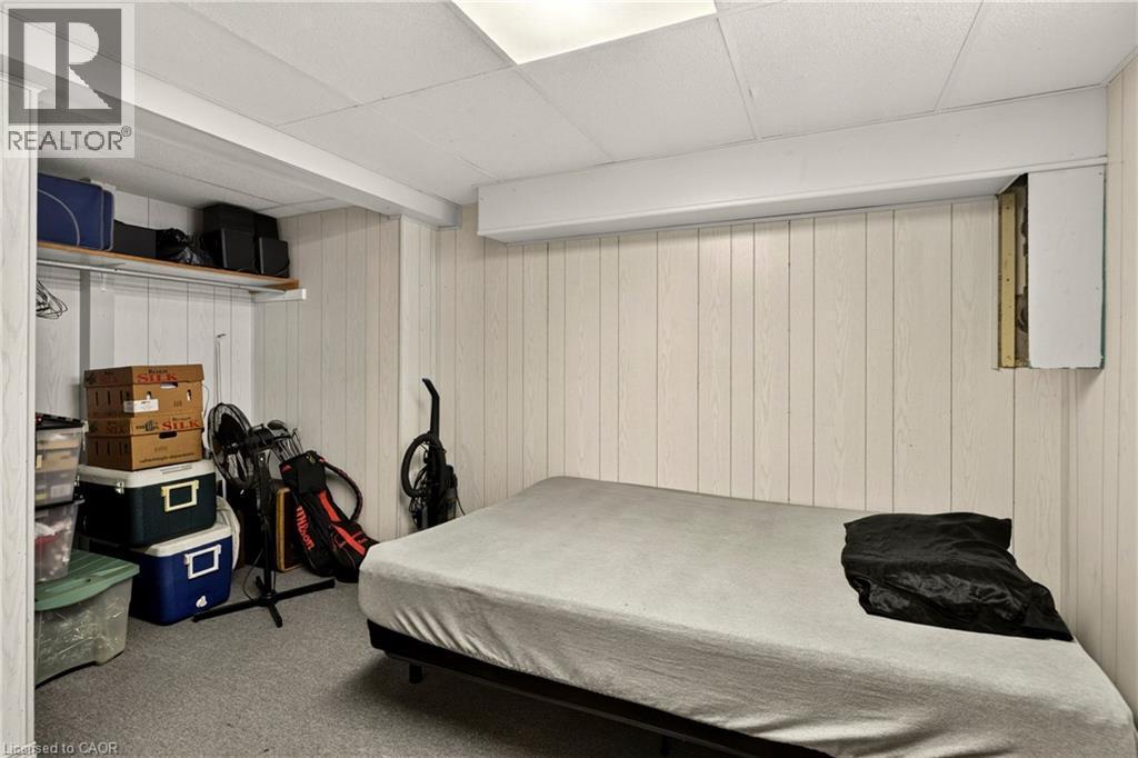 Room featuring light-toned vertical paneling and carpeted flooring - 958 Highland Road E, Hamilton, ON
