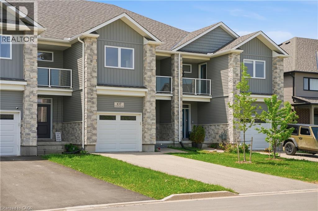 Contemporary townhome featuring stone and siding facade - 107 Stephenson Way, Palmerston, ON - Outdoor With Balcony With Facade
