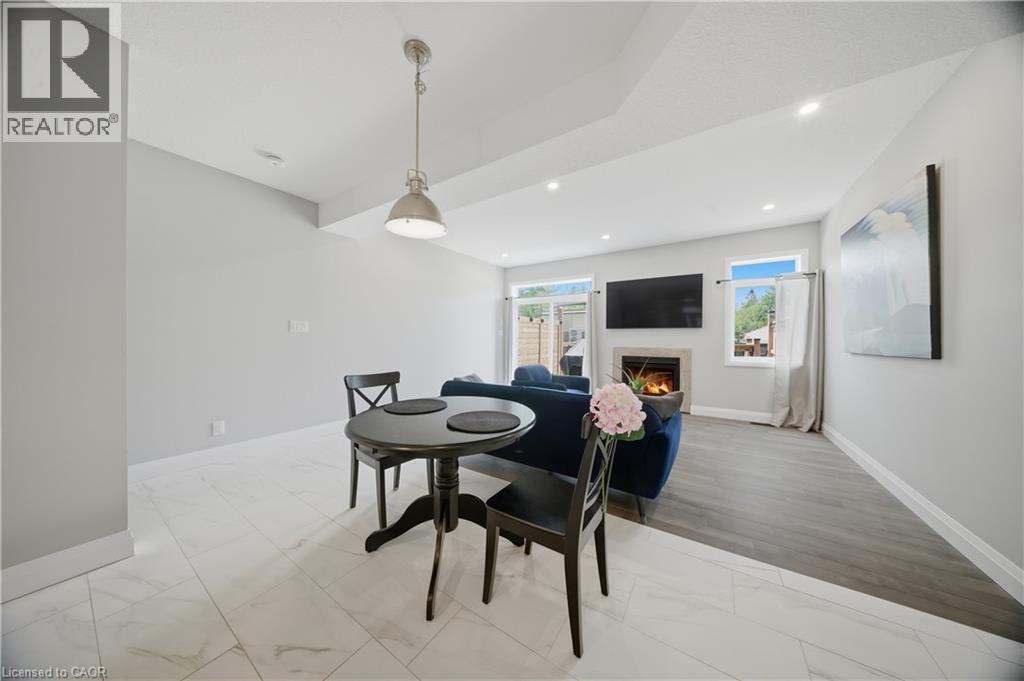 Open-concept living space featuring a fireplace, recessed lighting, and a neutral color palette - 107 Stephenson Way, Palmerston, ON - Indoor Photo Showing Dining Room With Fireplace