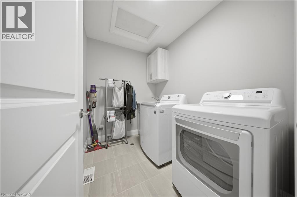 Laundry room featuring light-toned walls, tile flooring, and a white built-in cabinet - 107 Stephenson Way, Palmerston, ON - Indoor Photo Showing Laundry Room