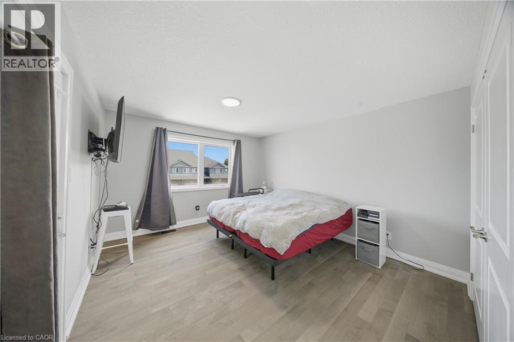 Spacious room featuring wood-finish flooring, light grey painted walls, and a recessed ceiling light - 107 Stephenson Way, Palmerston, ON - Indoor Photo Showing Bedroom