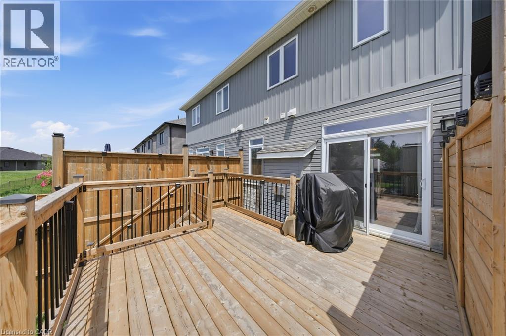 Expansive wood deck with black metal balusters, privacy fencing, and direct access to the interior via a sliding glass door - 107 Stephenson Way, Palmerston, ON - Outdoor With Deck Patio Veranda With Exterior