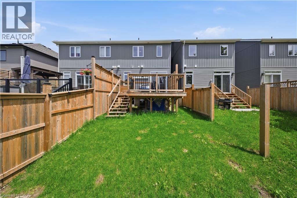 Fenced backyard featuring a wooden deck with railing, stairs, and a ground-level patio area - 107 Stephenson Way, Palmerston, ON - Outdoor With Deck Patio Veranda With Exterior