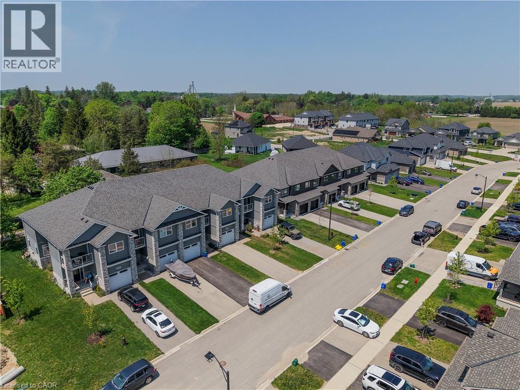 Modern townhome development featuring stone and siding exteriors, individual garage access, and private front entrances - 107 Stephenson Way, Palmerston, ON - Outdoor With View