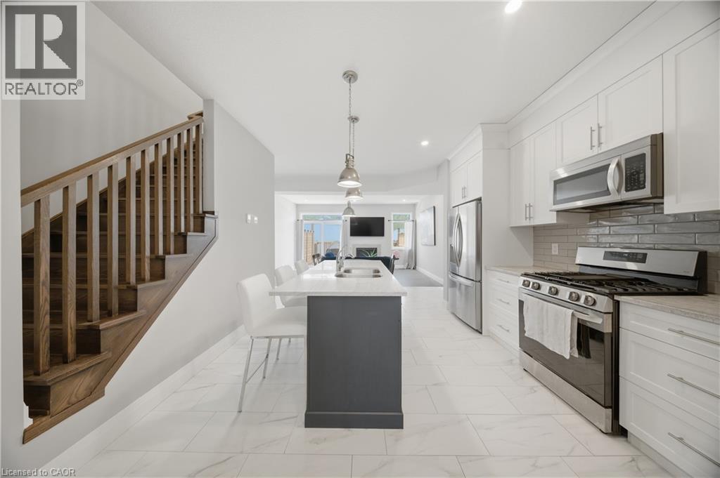 Contemporary kitchen with white cabinetry, stainless steel appliances, and light-toned countertops - 107 Stephenson Way, Palmerston, ON - Indoor Photo Showing Kitchen With Stainless Steel Kitchen With Upgraded Kitchen