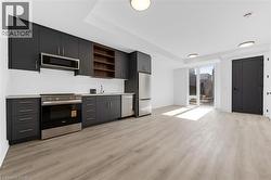 Open-concept living area featuring wood-finish flooring and recessed lighting -