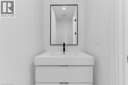 Floating vanity with integrated sink, matte black faucet, framed mirror, and contemporary drawer pulls -