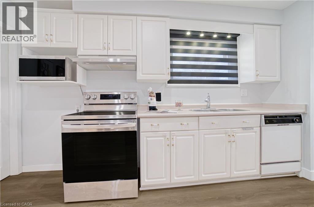 Kitchen featuring white cabinetry, light-toned countertops, a stainless steel electric range, and a built-in dishwasher - 60 Lysanda Avenue, London, ON - Indoor Photo Showing Kitchen