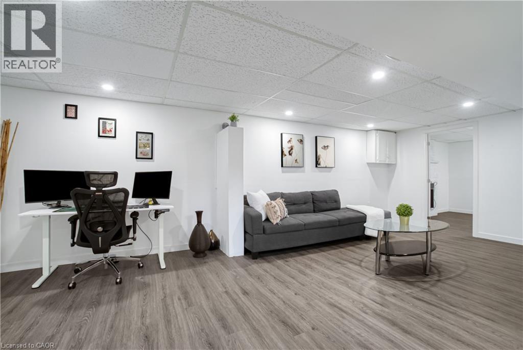 Finished room featuring wood-finish flooring, recessed lighting, and a drop-tile ceiling - 60 Lysanda Avenue, London, ON - Indoor Photo Showing Basement