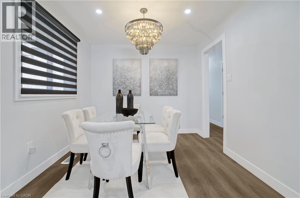 Dining area featuring wood-finish flooring, recessed lighting, and a tiered crystal chandelier - 60 Lysanda Avenue, London, ON - Indoor Photo Showing Dining Room