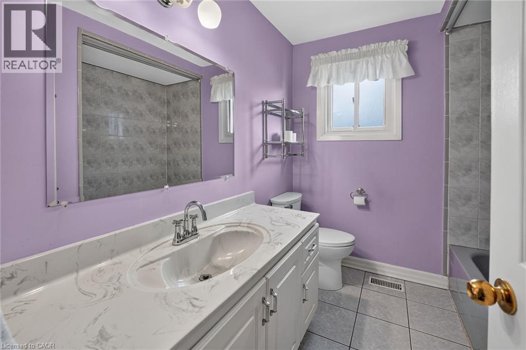 Bathroom vanity featuring a single basin, a chrome faucet, and a patterned countertop - 186 Glenmor Drive, Caledonia, ON - Indoor Photo Showing Bathroom