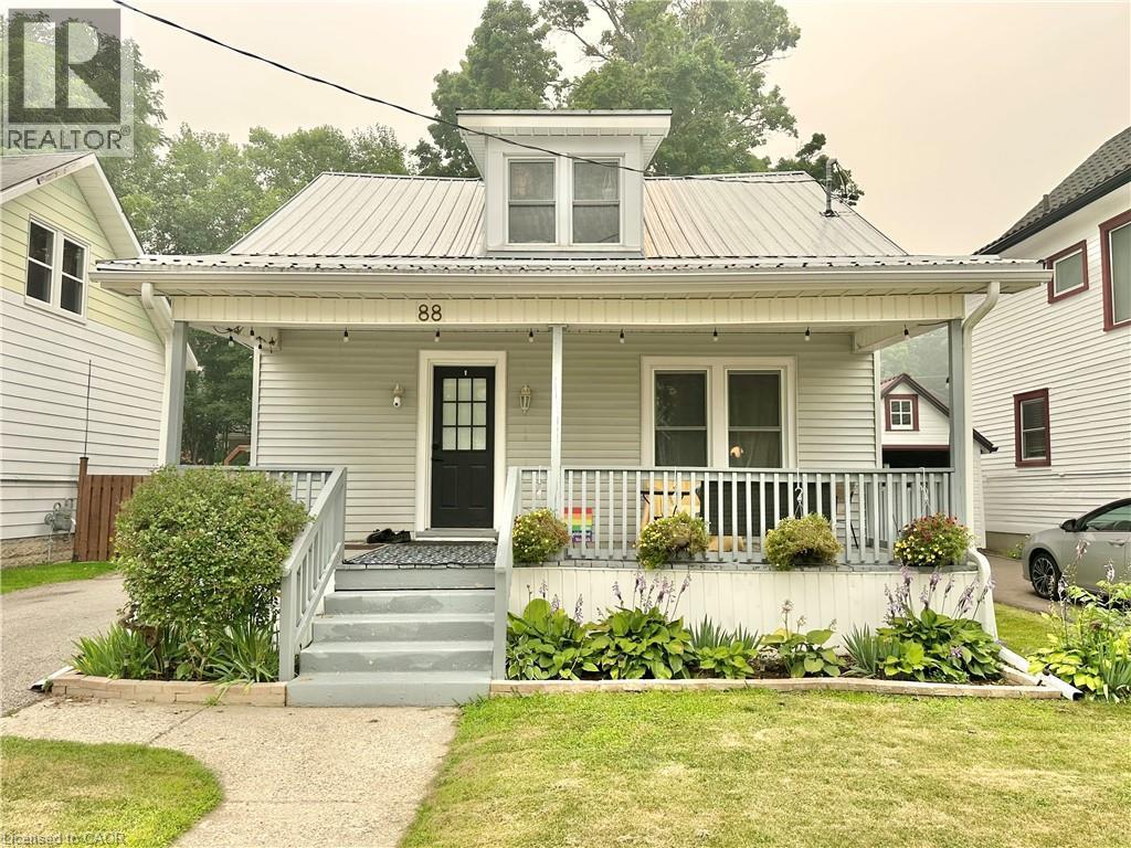 Light gray siding exterior with a metal roof and an upper dormer window - 88 Brook Street, Simcoe, ON - Outdoor With Deck Patio Veranda