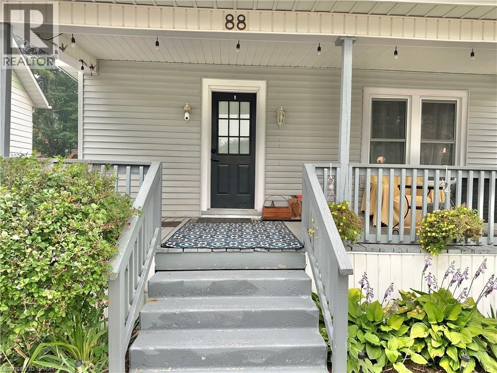 Front porch featuring a dark entry door with glass panes, light gray siding, and a contrasting white trim - 88 Brook Street, Simcoe, ON - Outdoor