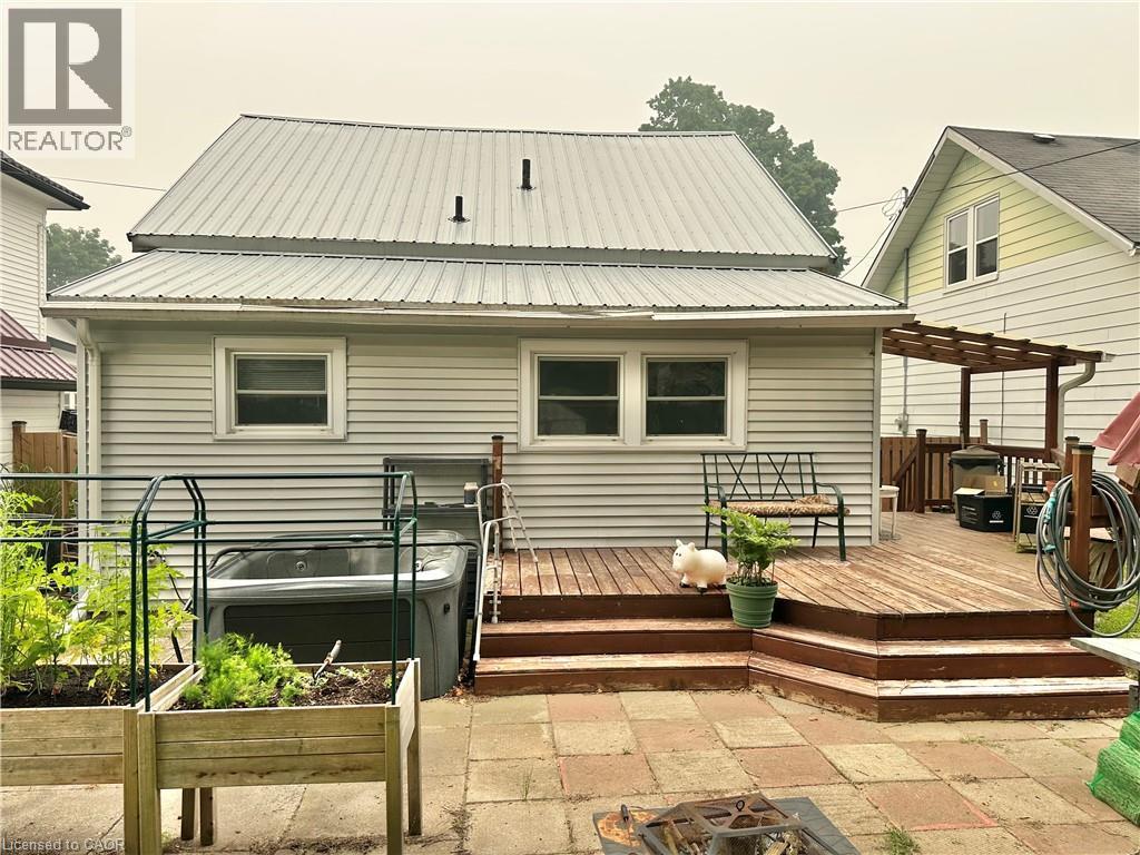 Rear exterior featuring light-colored siding and a metal roof - 88 Brook Street, Simcoe, ON - Outdoor With Exterior