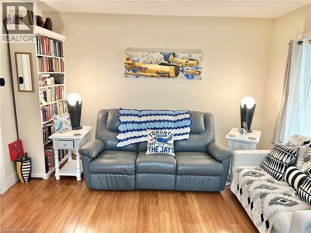 Warmly painted walls complement wood-finish flooring - 88 Brook Street, Simcoe, ON - Indoor Photo Showing Living Room