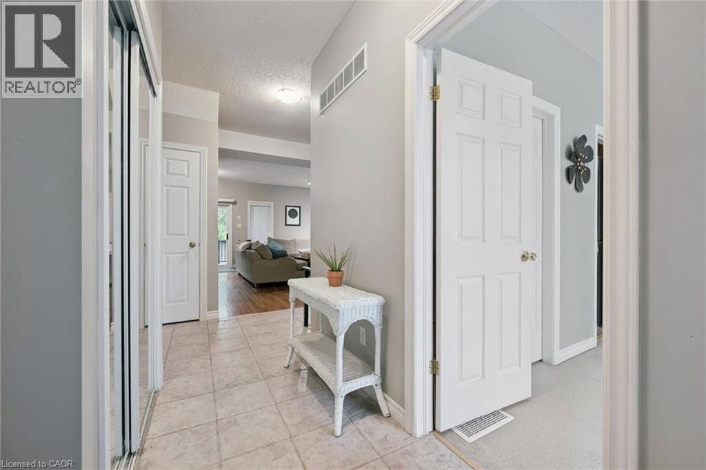 Foyer entry featuring ceramic tile flooring, a mirrored bi-fold closet, and white panel doors - 23 Knack Lane, Cambridge, ON - Indoor Photo Showing Other Room