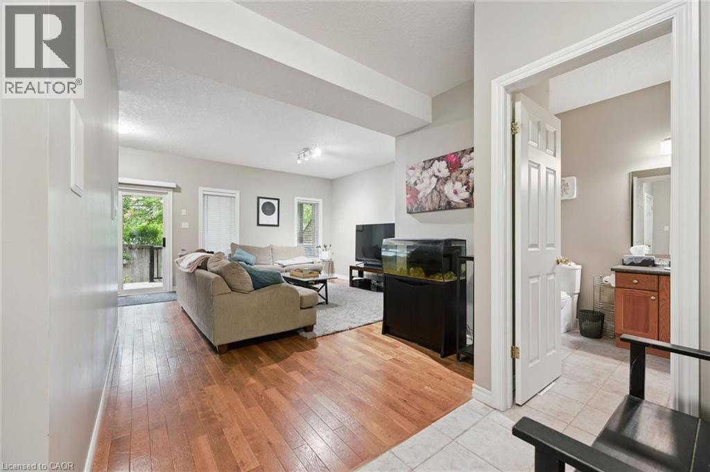 Living area featuring wood-finish flooring, recessed lighting, and a sliding glass door - 23 Knack Lane, Cambridge, ON - Indoor