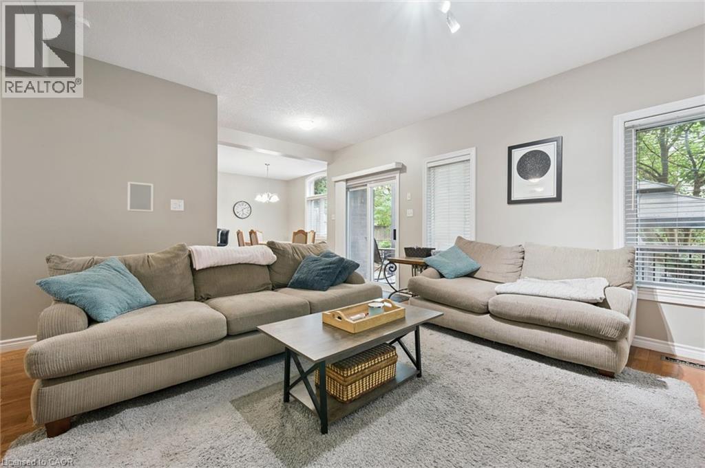 Living area featuring hardwood flooring, light neutral wall paint, and a sliding glass door - 23 Knack Lane, Cambridge, ON - Indoor Photo Showing Living Room