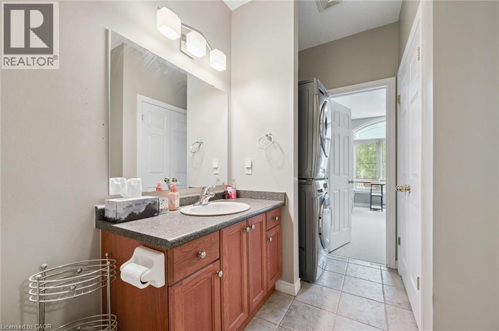 Vanity area featuring a wood-finish cabinet with a built-in sink, a wall-mounted mirror, and a three-light fixture - 23 Knack Lane, Cambridge, ON - Indoor Photo Showing Bathroom