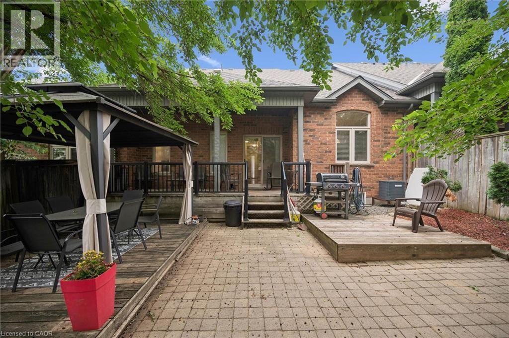 Expansive rear patio featuring a brick facade, wood-finish decking, and a covered gazebo dining area - 23 Knack Lane, Cambridge, ON - Outdoor With Deck Patio Veranda