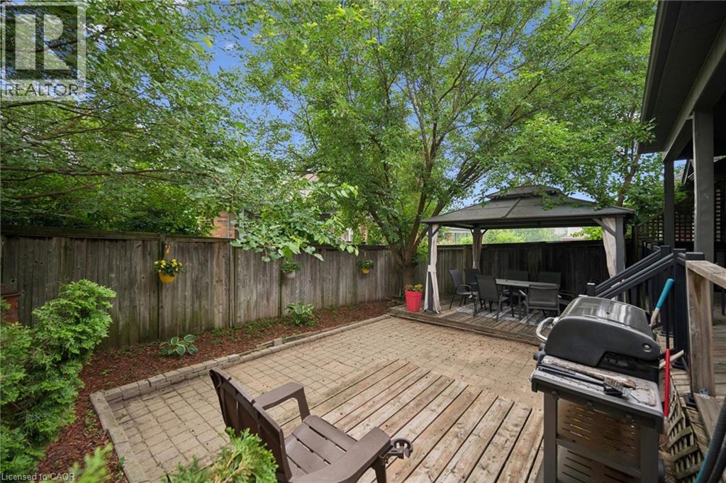 Private backyard featuring a fenced perimeter, a paved patio area, a raised wood deck, and an integrated gazebo structure - 23 Knack Lane, Cambridge, ON - Outdoor With Deck Patio Veranda